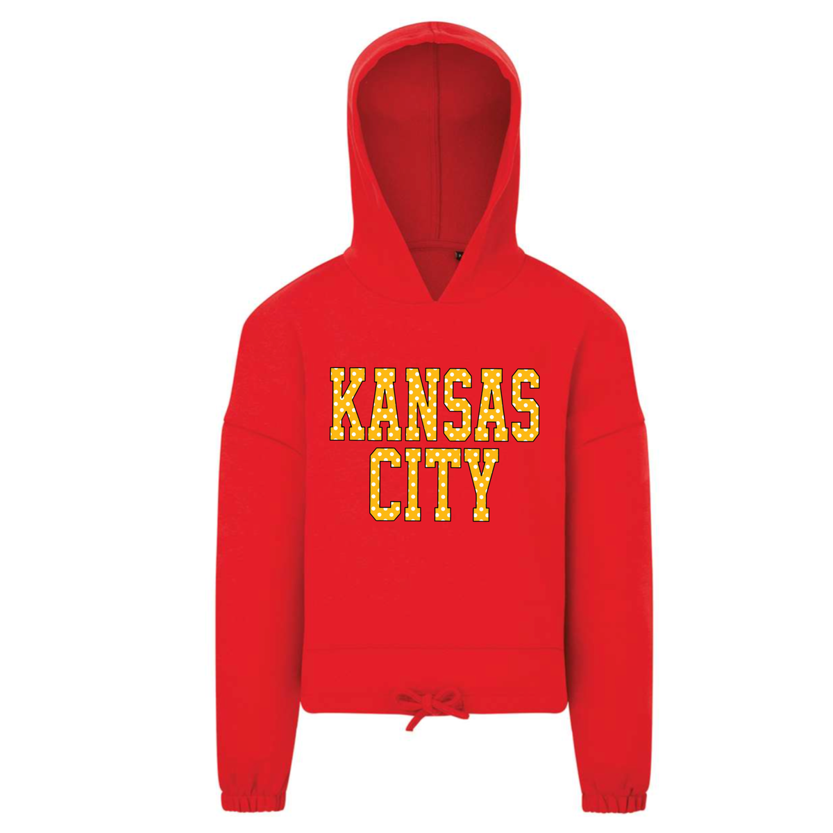 A bright red cropped pullover hoodie with 'KANSAS CITY' printed across the chest in yellow polka dot block letters, shown against a plain white background.